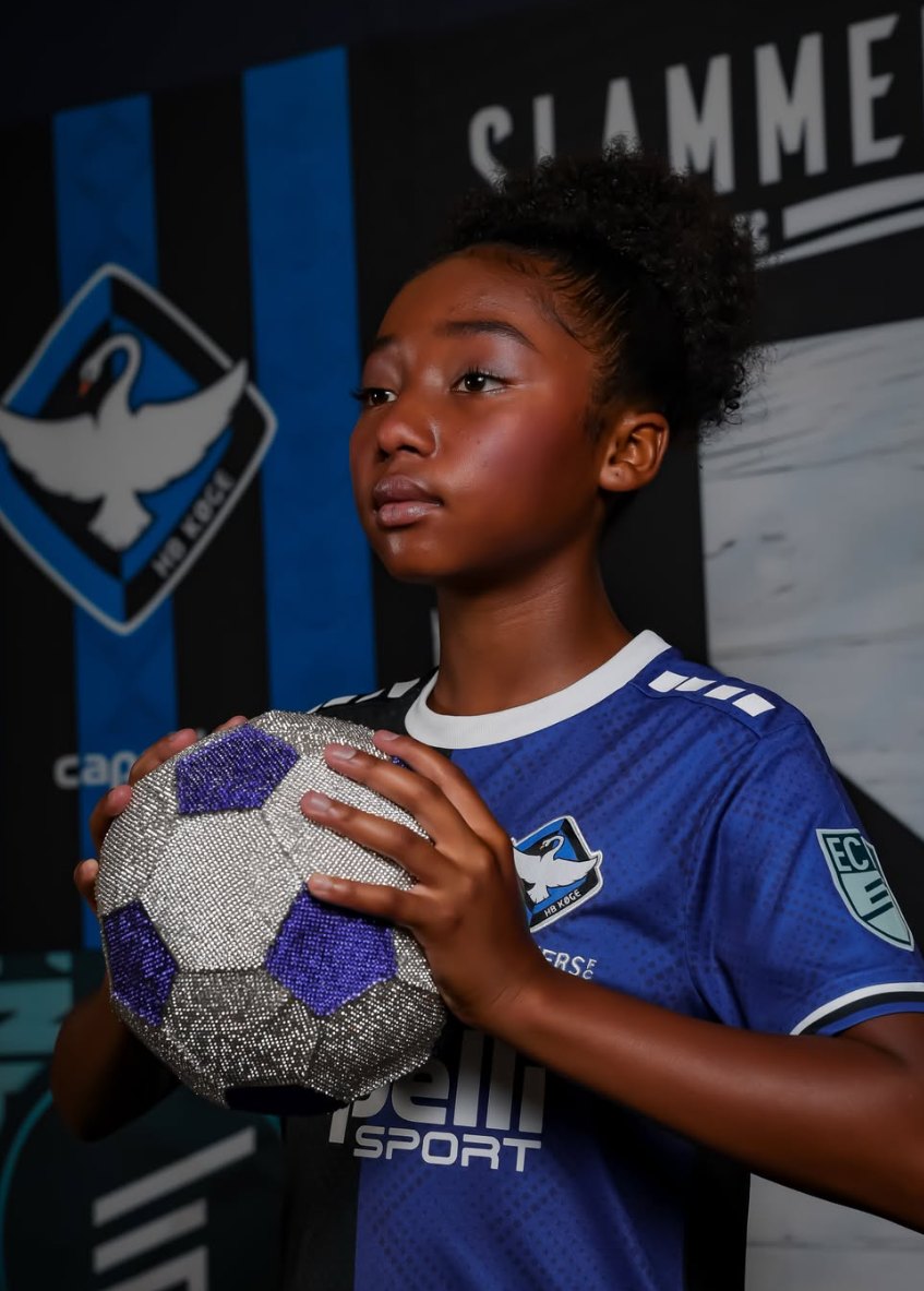 London in her Slammers kit, holding a ball